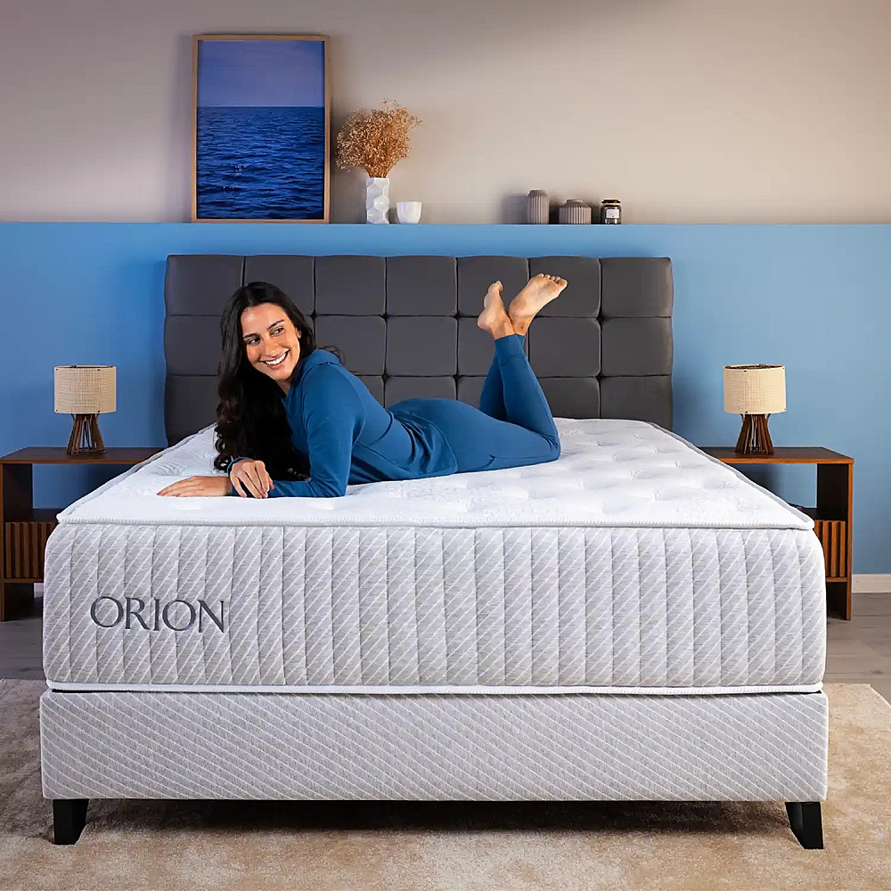 Colchão Ortobom Orion — mulher sorridente deitada sobre o colchão
